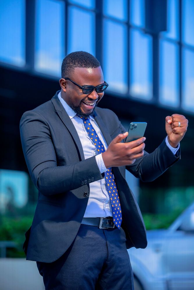 A business owner celebrating a confirmed payment on his phone